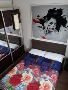 małą sypialnię z łóżkiem z kwiatami w obiekcie Apartament Brenda Sibiu w Sybinie