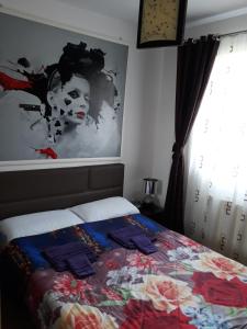 a bedroom with a bed with a picture of a woman at Apartament Brenda Sibiu in Sibiu