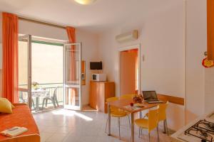 a living room with a table with a laptop on it at Casa Vacanze Isophylla in Finale Ligure