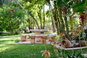 a garden area with tables, chairs, and plants at Masseria Le Lamie in Villa Castelli
