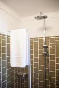 a bathroom with a shower with a white towel at Casa do Lado in Vila Nova de Milfontes +38 photos