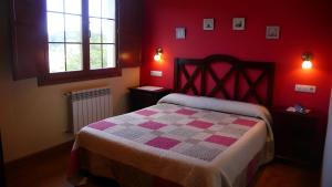 czerwona sypialnia z łóżkiem z kocem szachowym w obiekcie Apartamentos Rurales Casa Tata w mieście Villaviciosa