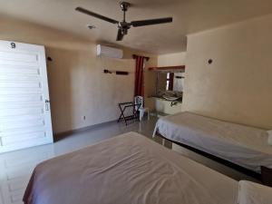 a bedroom with two beds and a sliding door at Las Cabañas del Doctor in Mahahual