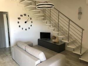 a living room with a staircase and a clock at Villa BOREA in Golfo Aranci
