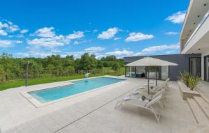 una piscina con dos sillas y una sombrilla en Villa Blanka, en Kringa