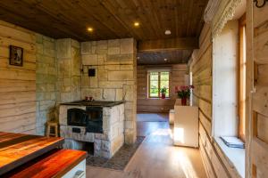 a living room with a stone fireplace in a log cabin at Jossi Holiday Home in Nasva