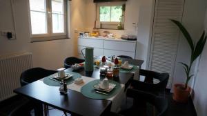 a dining room with a table and chairs and a kitchen at Huize Mesch in Eijsden