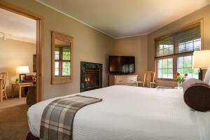a bedroom with a large white bed and a fireplace at Ashbrooke Hotel in Egg Harbor +26 photos