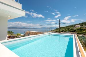 a swimming pool with a view of the ocean at Villa Talia in Donje Selo na Šolti
