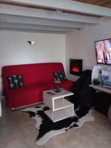 a living room with a red couch and a fireplace at Loft Les Tourelles in Andon