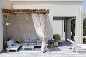 費拉約港的住宿－La Suite con Piscina Privata，庭院配有紫色沙发和天篷