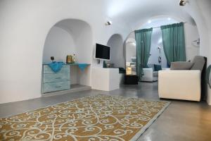 a living room with a couch and a tv at Serenity Blue (Cave house) in Akrotiri