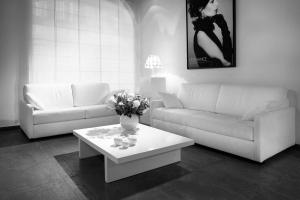 a living room with a couch and a table with flowers on it at La Maison Blanche in Beaune