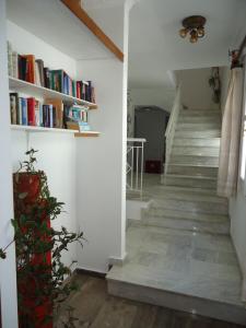 a staircase with bookshelves in a white room at Zorbas Hotel & Studios in Pythagoreio