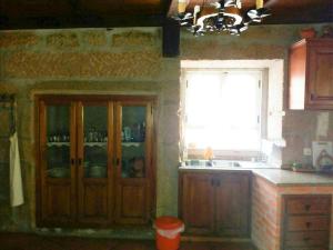 - une cuisine avec des portes en bois, une fenêtre et un évier dans l'établissement Casa de Campo Cabriz Casa do Brasileiro, à Vila Real