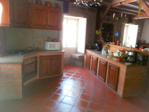 een keuken met houten kasten en een rode tegelvloer bij Casa de Campo Cabriz Casa do Brasileiro in Vila Real