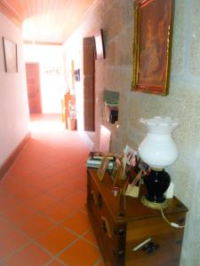 - un couloir avec une table et une lampe dans l'établissement Casa de Campo Cabriz Casa do Brasileiro, à Vila Real