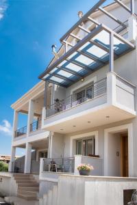 a large white house with a balcony at La Strada Apartment in Lefkada