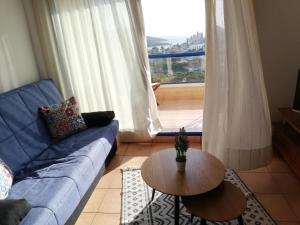 sala de estar con sofá, mesa y ventana en Apartment Monte Blanco, en La Manga del Mar Menor