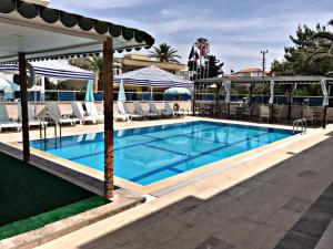 a large swimming pool with chairs and a resort at Lotus Otel in Tasucu