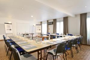 une salle de conférence avec de longues tables et chaises dans l'établissement Campanile Grenoble Nord - Moirans-Voreppe, à Moirans