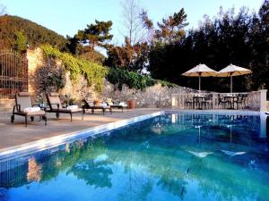 a swimming pool with chairs and umbrellas next to a wall at Hotel Villa Casanova in Lucca
