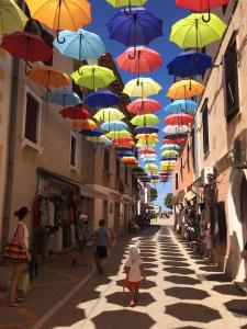 Eine Gruppe Regenschirme hängt über einer Straße in der Unterkunft Old City in Novigrad Istria