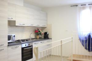 a kitchen with white cabinets and a sink and a microwave at Tuscany Life in Terricciola