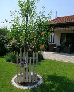 a wooden fence around a tree in a yard at Ferienwohnung Gitta in Dietersheim