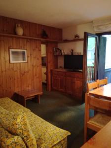 a bedroom with a bed and a tv and a table at Bilocale con box - Condominio Cardinello Rosa in Madesimo