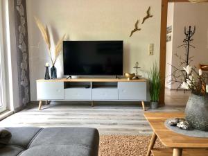 a living room with a television on a white entertainment center at Heimatliebe Fewo bei Stralsund in Steinhagen