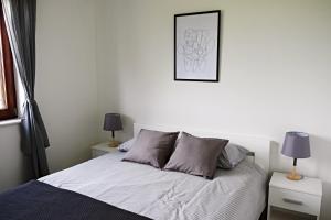 een slaapkamer met een bed en twee lampen en een foto bij Apartment Luna in Umag