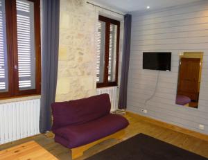 サンテステフにあるAu cœur des vignoblesのリビングルーム(紫色のソファ、テレビ付)