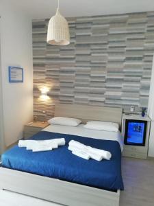 トッレ・ラピッロにあるSabbia Bianca Affittacamereのベッドルーム1室(ブルーベッド1台、タオル付)