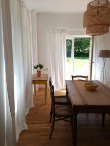 a dining room with a table and chairs and a window at Riverside house in Chiny