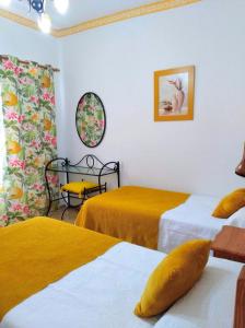 Habitación con 2 camas con sábanas amarillas. en Pensión Los Volcanes, en Fuencaliente de la Palma