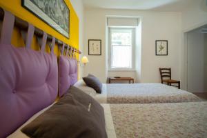 トレントにあるB&B La Malvasiaのベッドルーム1室(紫と黄色の壁のベッド2台付)