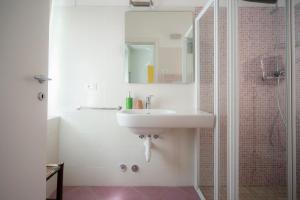 y baño blanco con lavabo y ducha. en B&B La Malvasia, en Trento