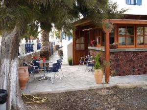 a patio with chairs and a table and a building at 5bedroom villa in perissa beach in Perissa