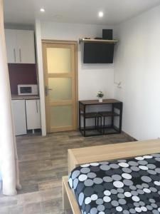 ein Zimmer mit einem Bett, einem Tisch und einer Tür in der Unterkunft Les Condamines in Antoingt