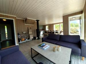 uma sala de estar com sofás roxos e uma mesa em Explorers Cabin Lofoten em Offersøya