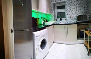 een keuken met een wasmachine en droger. bij 2 ROOMS ANNEX (TV+WiFi) in Chigwell