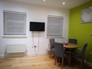 a room with a table and chairs and a television at 2 ROOMS ANNEX (TV+WiFi) in Chigwell