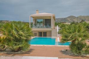 a villa with a swimming pool and a house at Villa Pelagos in Koutsounari