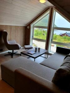 a living room with a couch and a table at Explorers Cabin Lofoten in Offersøya