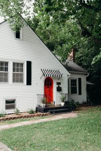 ein weißes Haus mit einer roten Tür in der Unterkunft The Paddock Luxury Vacation Home in Hot Springs