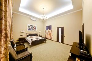 a bedroom with a bed and a tv in a room at Frapolli Hotel on Deribasivska street in Odesa