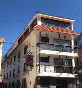 Edificio alto de color blanco con balcón en Hotel La Posada de Francisca, en Písac