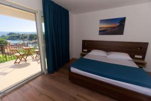 una camera da letto con un letto e un balcone di Villa Nerium a Malinska Altre 41 foto