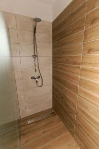 e bagno con doccia e parete in legno. di Villa Nerium a Malinska